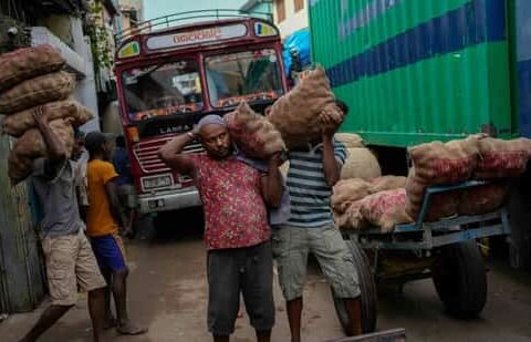 Laborers load sacks of imported potatoes to hand carts at a market place in Colombo, Sri Lanka. The International Monetary Fund said Monday that its executive board has approved a nearly $3 billion bailout program for Sri Lanka over four years to help salvage the country's bankrupt economy. (AP)