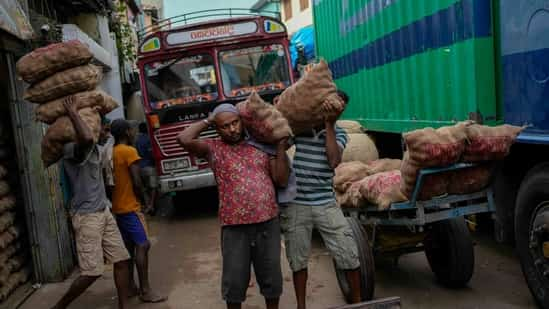 Laborers load sacks of imported potatoes to hand carts at a market place in Colombo, Sri Lanka. The International Monetary Fund said Monday that its executive board has approved a nearly $3 billion bailout program for Sri Lanka over four years to help salvage the country's bankrupt economy. (AP)