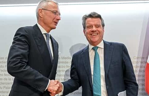 UBS Chairman Colm Kelleher (R) shakes hands with Credit Suisse chairman Axel Lehmann (L) after a press conference. (AFP)