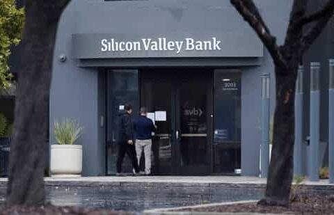 A man puts a sign on the door of the Silicon Valley Bank as an onlooker watches at the bank’s headquarters in Santa Clara, California(REUTERS)