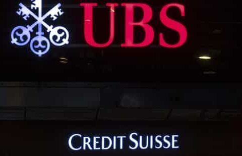 The illuminated logos of the Swiss banks Credit Suisse and UBS in Zurich, Switzerland. (AP)