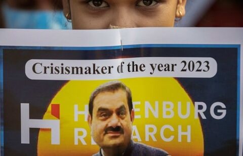 An activist of the youth wing of Congress party holds a placard featuring Gautam Adani, chairman of Adani Group, during a protest.(Reuters)