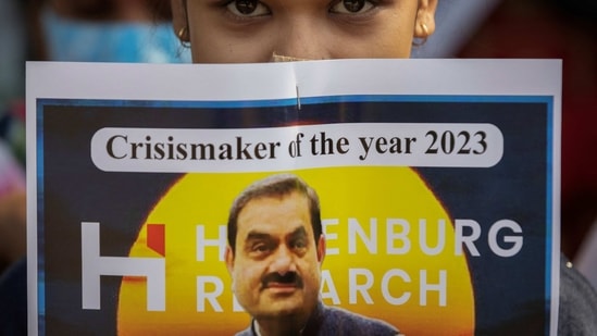 An activist of the youth wing of Congress party holds a placard featuring Gautam Adani, chairman of Adani Group, during a protest.(Reuters)