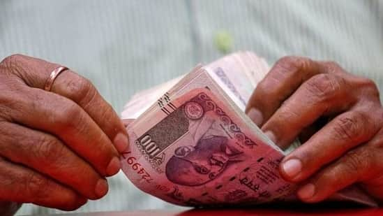 A man counts Indian currency notes inside a shop in Mumbai. The Indian rupee on Thursday had closed at 71.03 against the US dollar.(REUTERS)