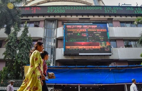 Market updates today: People walk past an electronic signage displayed at the Bombay Stock Exchange (BSE) building.(PTI)