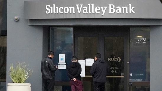 People look at signs posted outside of an entrance to Silicon Valley Bank in Santa Clara, California.(AP)