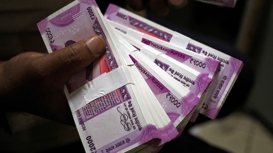 A cashier displays the new 2000 Indian rupee banknotes inside a bank in Jammu.(REUTERS)