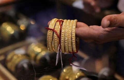 A salesperson shows gold bangles to a customer at a jewellery showroom during Dhanteras, a Hindu festival associated with Lakshmi, the goddess of wealth, in Mumbai, India, (File)(REUTERS)