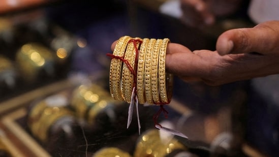 A salesperson shows gold bangles to a customer at a jewellery showroom during Dhanteras, a Hindu festival associated with Lakshmi, the goddess of wealth, in Mumbai, India, (File)(REUTERS)