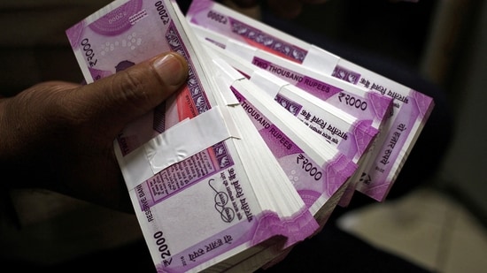 A cashier displays the new 2000 Indian rupee banknotes inside a bank in Jammu.(REUTERS)