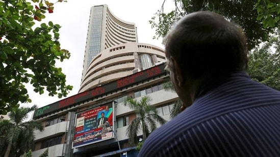 Sensex, Nifty updates: A man looks at a screen across a road displaying the Sensex on the facade of the Bombay Stock Exchange (BSE) building in Mumbai, India. (REUTERS)