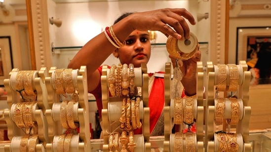 A saleswoman shows gold bangles to a customer at a jewellery showroom in Kolkata, India.(REUTERS/ File)