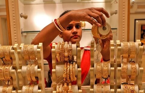 A saleswoman shows gold bangles to a customer at a jewellery showroom in Kolkata, India.(REUTERS/ File)