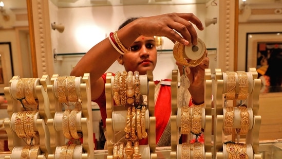 A saleswoman shows gold bangles to a customer at a jewellery showroom in Kolkata, India.(REUTERS/ File)