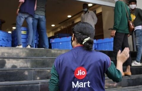 A woman wearing a Reliance JioMart vest instructs workers as they stock their products inside a Future Retail's closed Big Bazaar retail store in Mumbai.(Reuters / File)