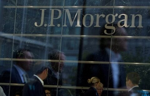 Workers are reflected in the windows of the Canary Wharf offices of JP Morgan in London.(Reuters)