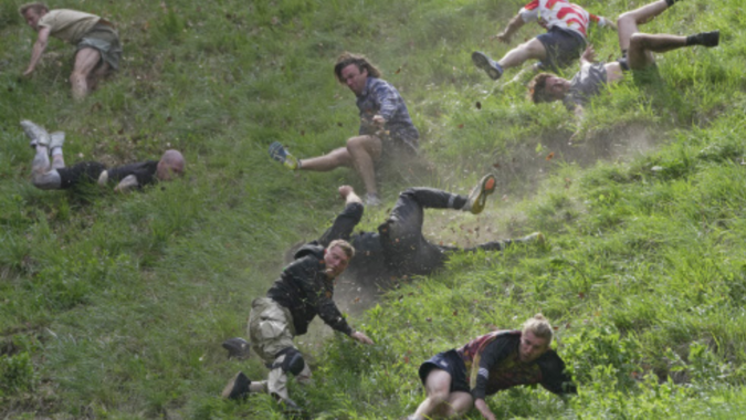 Rolling thunder: Contestants chase cheese wheel down a hill in chaotic UK race