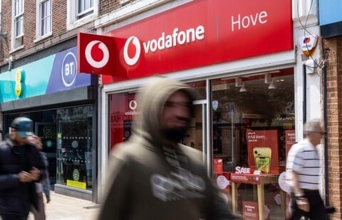 Pedestrians pass a Vodafone Group Plc store in Hove, UK, on Monday.(Bloomberg)