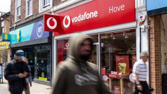 Pedestrians pass a Vodafone Group Plc store in Hove, UK, on Monday.(Bloomberg)