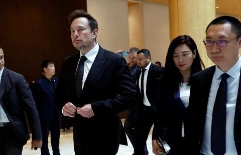 Tesla chief executive officer Elon Musk walks next to Tesla's Senior Vice President Tom Zhu and Vice President Grace Tao as he leaves a hotel in Beijing, China(REUTERS)