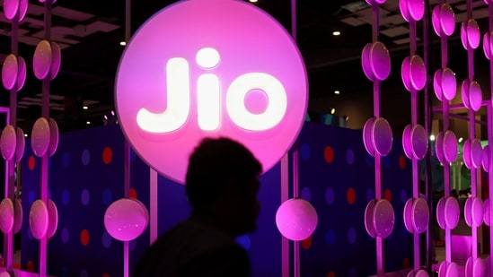 A man walks across the LED board showing the logo of Jio(REUTERS)