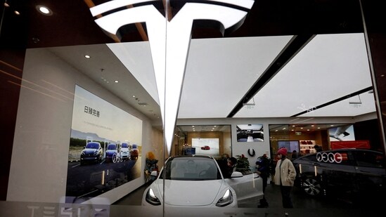 Visitors check a Tesla Model 3 car next to a Model Y displayed at a showroom of the U.S. electric vehicle (EV) maker in Beijing, China.(REUTERS)