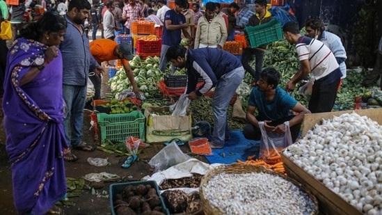 Vegetable vendors and customers at a wholesale vegetable market in Bengaluru. (Bloomberg)