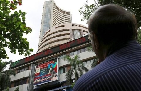 A man looks at a screen across a road displaying the Sensex on the facade of the Bombay Stock Exchange (BSE) building in Mumbai.(REUTERS)