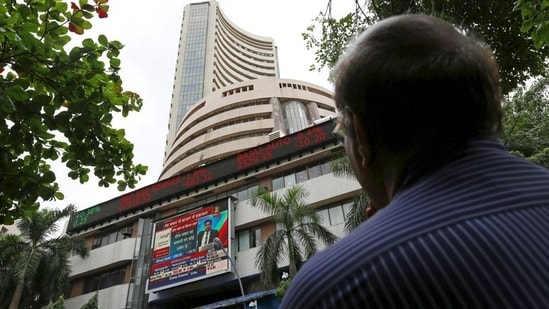 A man looks at a screen across a road displaying the Sensex on the facade of the Bombay Stock Exchange (BSE) building in Mumbai.(REUTERS)