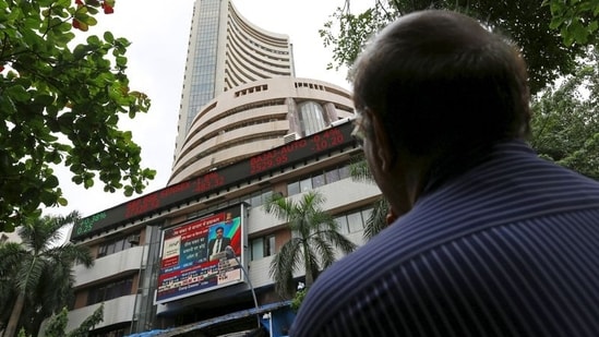 A man looks at a screen across a road displaying the Sensex on the facade of the Bombay Stock Exchange (BSE) building in Mumbai.(REUTERS)