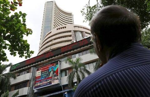 A man looks at a screen across a road displaying the Sensex on the facade of the Bombay Stock Exchange (BSE) building in Mumbai.(REUTERS)