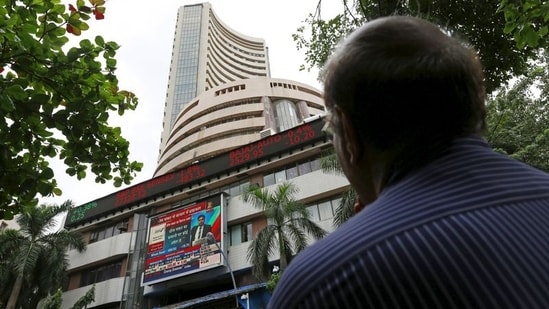 A man looks at a screen across a road displaying the Sensex on the facade of the Bombay Stock Exchange (BSE) building in Mumbai.(REUTERS)