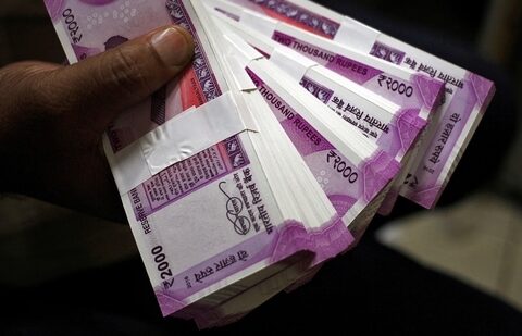 A cashier displays the new 2000 Indian rupee banknotes inside a bank in Jammu. (Reuters)