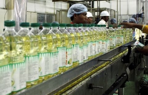 Employees fill plastic bottles with edible oil at an oil refinery plant of Adani Wilmar Ltd, a leading edible oil maker, in Mundra, 375 km (233 miles) from the western Indian city of Ahmedabad, June 10, 2009. (Amit Dave/Reuters)