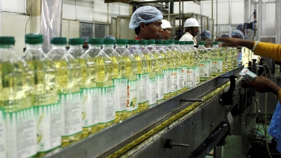 Employees fill plastic bottles with edible oil at an oil refinery plant of Adani Wilmar Ltd, a leading edible oil maker, in Mundra, 375 km (233 miles) from the western Indian city of Ahmedabad, June 10, 2009. (Amit Dave/Reuters)