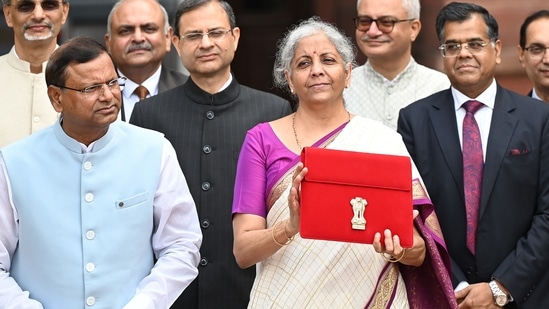 Union Finance Minister Nirmala Sitharaman showcases a red pouch carrying the Budget documents, outside the Finance Ministry in North Block (Hindustan Times)