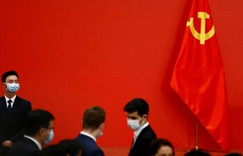 A security personnel keeps watch next to a Chinese Communist Party flag.(Reuters)