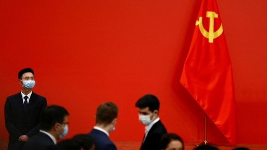 A security personnel keeps watch next to a Chinese Communist Party flag.(Reuters)