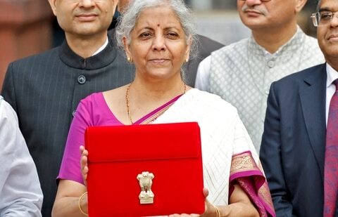 Finance minister Nirmala Sitharaman holds up a folder with the Government of India's logo as she leaves her office to present the union budget in the parliament in New Delhi.