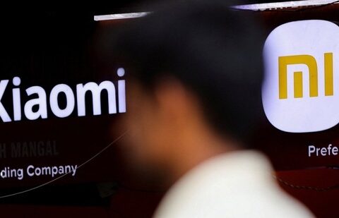 A man walks past a logo of Xiaomi, a Chinese manufacturer of consumer electronics, outside a shop.(Reuters)