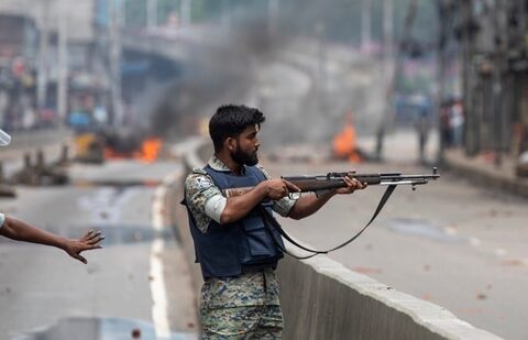 Bangladesh crisis: A policeman aims his weapon at protesters during a curfew imposed following violence during protests against Prime Minister Sheikh Hasina and her government, in Dhaka, Bangladesh.(AP)