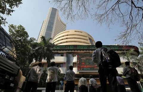 People look at a screen displaying the Sensex results on the facade of the Bombay Stock Exchange (BSE) building in Mumbai. (Reuters)