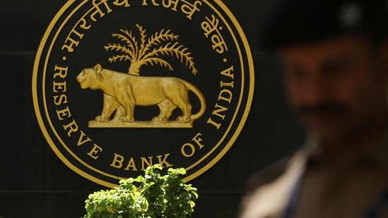 RBI MPC Meet 2024 Expectations Live: A police officer walks past the Reserve Bank of India (RBI) logo inside its headquarters in Mumbai, India.