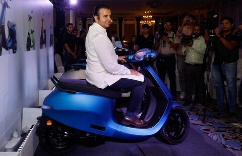 Bhavish Aggarwal, CEO of Ola Cabs, and founder of Ola Electric, sits on an Ola electric scooter after the press conference before the company's IPO launch in Mumbai. (Reuters)