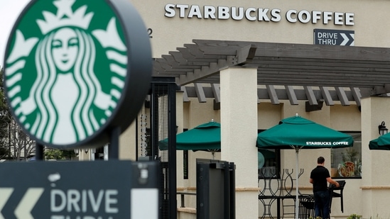 A worker puts away patio furniture at a Starbucks Corp drive-through location in Oceanside, California, U,S. May 29, 2018 (Mike Blake/Reuters)