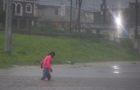 A man walks in a flooded street as Hurricane Beryl hits the southern coast of the island, in Kingston, Jamaica, July 3, 2024. (Marco Bello/Reuters)