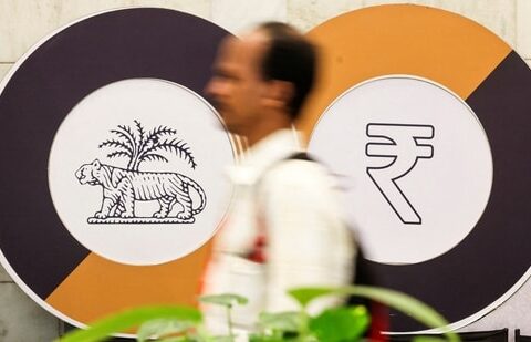 A man walks past a logo of the Reserve Bank of India (RBI) and the Indian Rupee inside the RBI headquarters in Mumbai. (Reuters)
