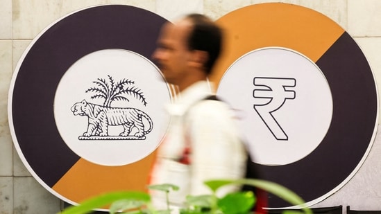 A man walks past a logo of the Reserve Bank of India (RBI) and the Indian Rupee inside the RBI headquarters in Mumbai. (Reuters)