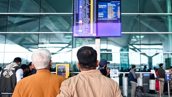 Passengers look at a flight information display as many IndiGo flights stand cancelled at Indira Gandhi International Airport in New Delhi on Friday, 5 December 2025. (ANI)