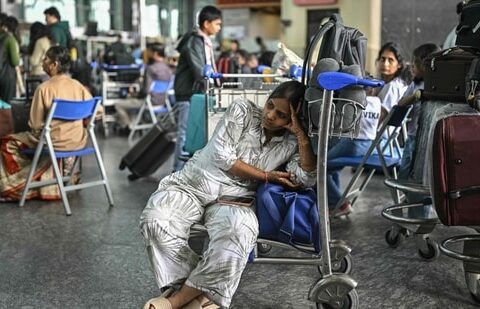 IndiGo shares crash as much as 6.63% after CEO asked to explain flight cancellations| Business News A passenger waits outside the IndiGo Airlines kiosk at the Kempegowda International Airport in Bengaluru on 6 December. (AFP)